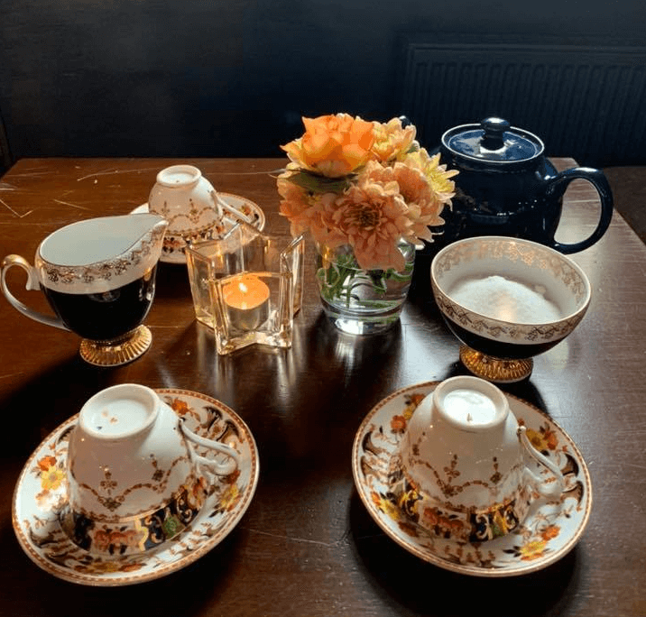 candle, flowers and tea pot in a pub